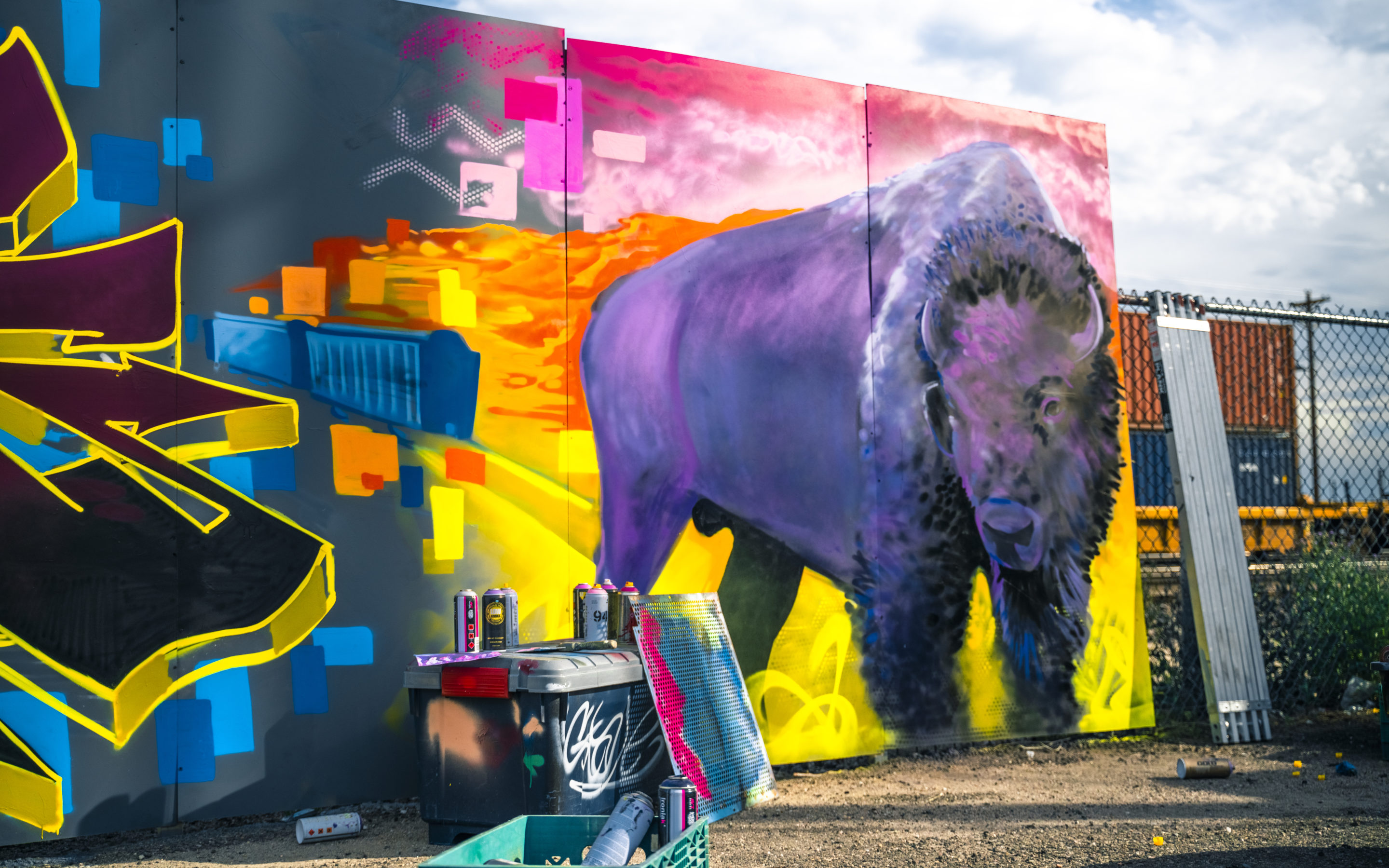 Purple bison spray painted with orange hills in the background