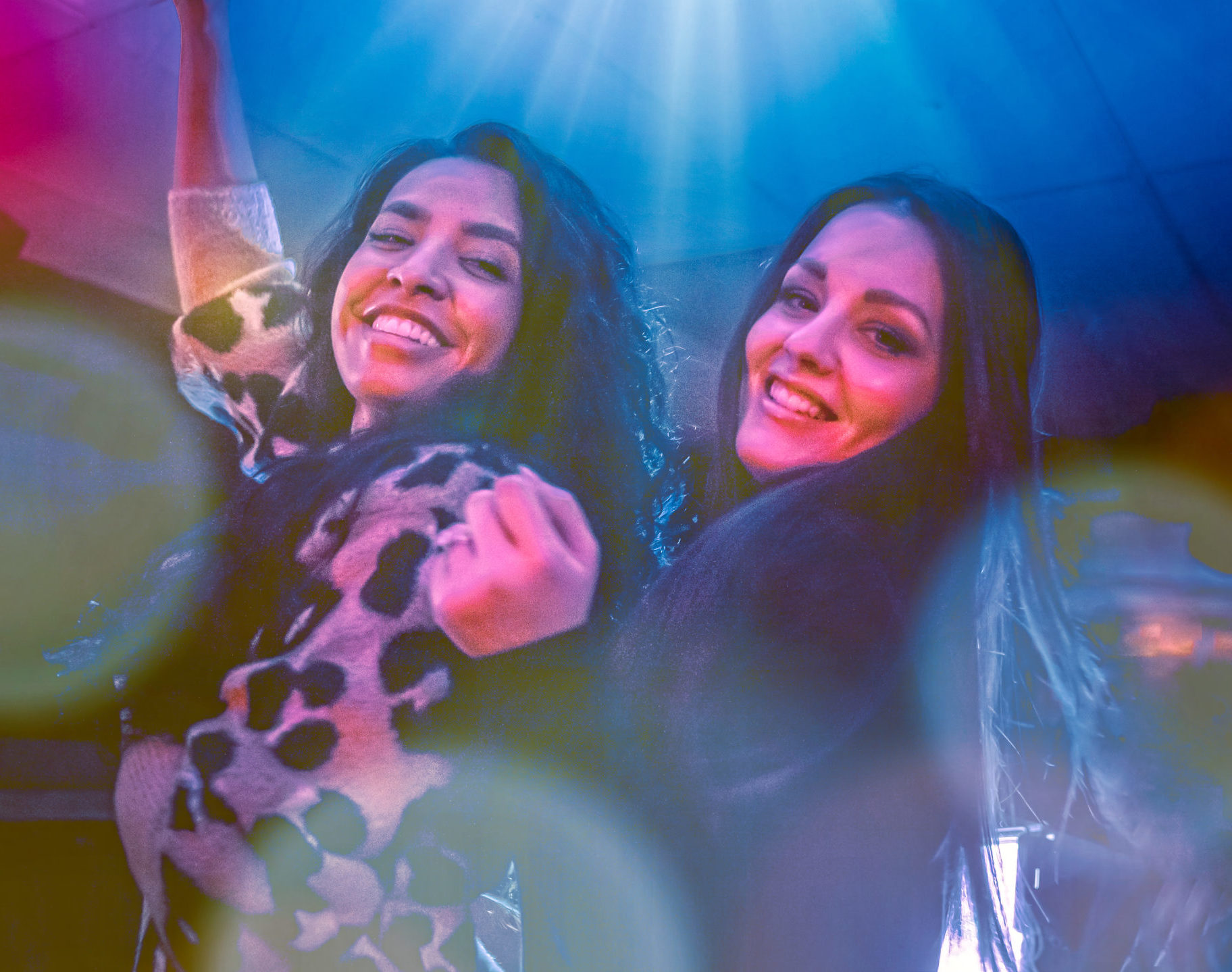 Two women dancing with colorful background